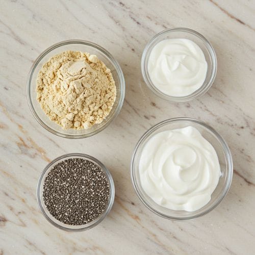 vanilla protein powder greek yogurt and chia seeds in small glass bowls